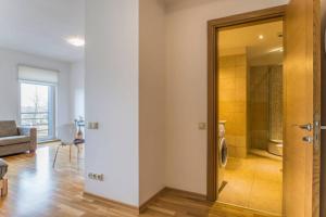 a living room with a door leading to a bathroom at Riga Apartment in the Heart of City in Rīga