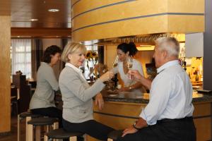 un grupo de personas sentadas alrededor de un bar en Hotel Ochsen, en Menzingen