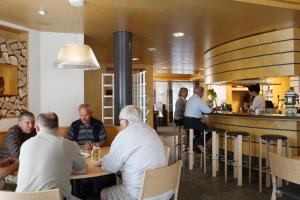 un grupo de personas sentadas en un bar en un restaurante en Hotel Ochsen, en Menzingen