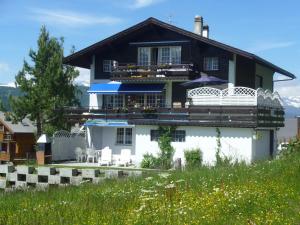 una casa blanca con techo negro en Haus Edelweiss, en Grächen