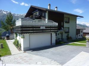 Casa blanca con garaje grande en la entrada en Haus Edelweiss, en Grächen