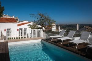 - une piscine avec 2 chaises et une maison dans l'établissement Lugares Com História, à Óbidos