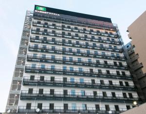 a tall building with scaffolding on the side of it at R&B Hotel Shin Osaka Kitaguchi in Osaka