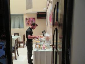 a man standing in front of a table with food at UTASA VILLA REAL inn in Puno