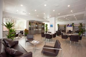 a waiting room with tables and chairs in a building at Best Western Plus Borgolecco Hotel in Arcore