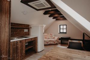 a kitchen and living room with a couch and a table at Penzion Víno Hruška Pardubice in Pardubice