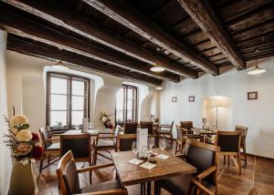 a restaurant with wooden tables and chairs and windows at Penzion Víno Hruška Pardubice in Pardubice