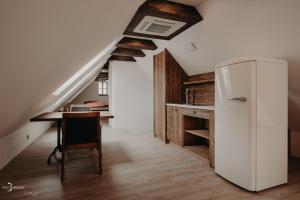 a refrigerator in a room with a table and a staircase at Penzion Víno Hruška Pardubice in Pardubice