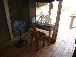 een kamer met een bureau, een ventilator en een stoel bij Roika Tarangire Tented Lodge in Kwa Kuchinia