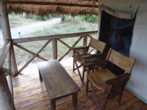 een groep stoelen en een tafel op een veranda bij Roika Tarangire Tented Lodge in Kwa Kuchinia