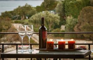 una botella de vino y dos copas en una mesa con velas en Villa Perris Studios, en Kassiopi