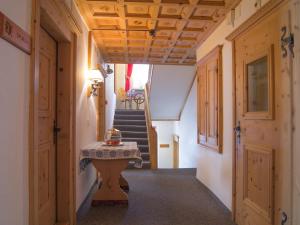 a hallway with a table and stairs in a house at Hotel Alpina in Zernez