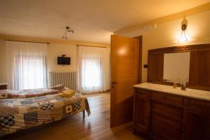 a bedroom with a bed and a sink and a mirror at B&B da Toi in Marostica