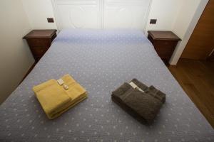 a bed with two bags sitting on top of it at B&B da Toi in Marostica