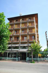 un edificio con un albero di fronte di Hotel Salus a Montecatini Terme