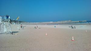 eine Gruppe von Menschen am Strand mit einem Rettungsturm in der Unterkunft El Terrero in Lamadrid