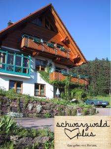 a large house with a wooden roof at Ferienwohnung Kaufmann in Baiersbronn