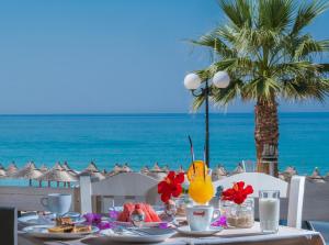 - une table avec de la nourriture et une vue sur l'océan dans l'établissement WhiteSands Beach Resort, à Paralia Vrachou