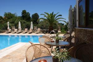 d'une terrasse avec des tables et des chaises à côté de la piscine. dans l'établissement Harmony Hotel Apartments, à Selianitika