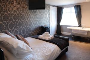 um quarto com uma cama, um lavatório e uma banheira em The Windmill Inn - Whitby em Whitby