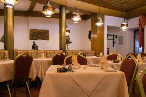 een eetkamer met tafels, stoelen en verlichting bij Post-Hotel in Mittenwald