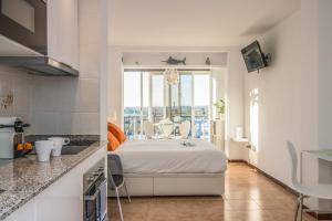 a bedroom with a bed and a large window at Holidays Penthouse vues panoramiques sur le Port naval,un séjour élégant assuré " Wifi Pàrquing gratuït in Roses