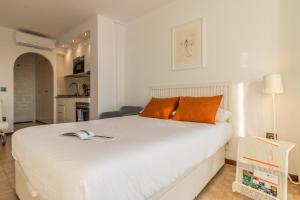 a bedroom with a large white bed with orange pillows at Holidays Penthouse vues panoramiques sur le Port naval,un séjour élégant assuré " Wifi Pàrquing gratuït in Roses