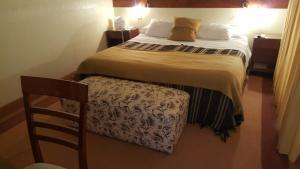 1 dormitorio con 1 cama grande y 1 silla en Ohasis Hotel Jujuy & Spa, en San Salvador de Jujuy