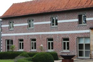 een rood bakstenen gebouw met een rood dak bij Mille Étoiles in Moorsel