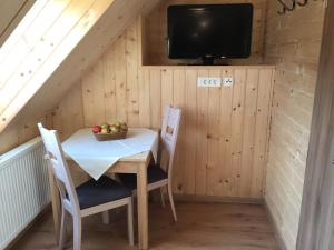 een eetkamer met een tafel en stoelen en een tv bij Apartmaji in sobe Tina in Kranjska Gora