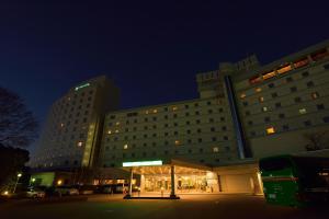 a large building with a parking lot in front of it at Narita Tobu Hotel Airport in Narita