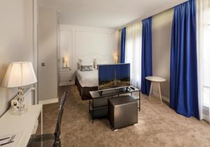 een hotelkamer met een slaapkamer met een bed en een televisie bij Hôtel Paris Vaugirard in Parijs