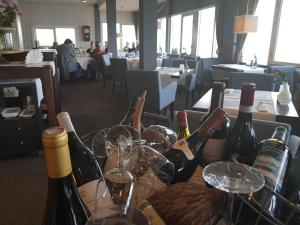 un montón de botellas de vino y copas en una mesa en Eemshotel, en Delfzijl