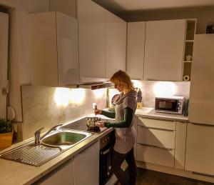 Uma mulher na cozinha a preparar comida. em Ferienhaus im Erzgebirge em Chemnitz