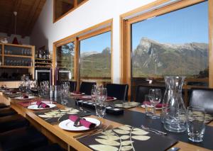 een lange tafel in een restaurant met uitzicht op de bergen bij Chalet Brio in Samoëns