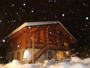 een huis in de sneeuw met sneeuwval bij Chalet Brio in Samoëns