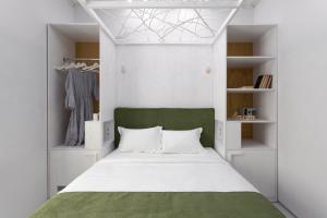 a bedroom with a green and white bed and shelves at City Hotel Bortoli by Ribas in Odesa