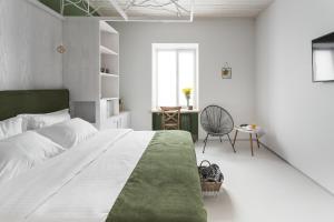 a bedroom with a large bed with a green blanket at City Hotel Bortoli by Ribas in Odesa