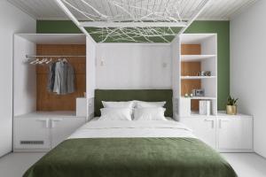 a bedroom with a large bed with a green blanket at City Hotel Bortoli by Ribas in Odesa