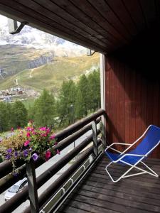 una silla azul sentada en un porche con vistas en CERVINIA - Appartamento direttamente sulle piste, vista unica sul Cervino, en Breuil-Cervinia