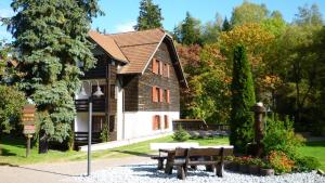 un edificio con una mesa y bancos delante en Hapimag Ferienwohnungen Braunlage, en Braunlage