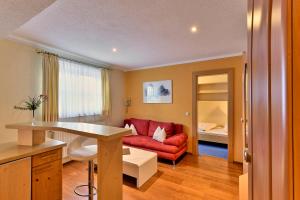 a living room with a red couch in a room at Pension Regina in Lech am Arlberg