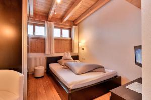 a small bedroom with a bed and a window at Pension Regina in Lech am Arlberg