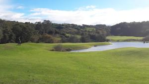 einen Golfplatz mit einem Teich auf einem Grün in der Unterkunft El Terrero in Lamadrid