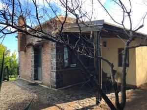 una vieja casa de ladrillo con un árbol en primer plano en B&B Villa Loriana, en Milo