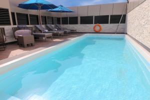 een groot blauw zwembad met stoelen en parasols bij Paradise Elite Hotel Al-Tahlia Jeddah in Jeddah