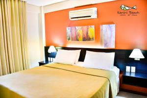 ein Hotelzimmer mit einem Bett mit orangefarbener Wand in der Unterkunft Kariri Beach Hotel in Cumbuco