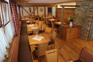 einen Blick über ein Restaurant mit Holztischen und Stühlen in der Unterkunft Alpenhof Annaberg in Annaberg im Lammertal