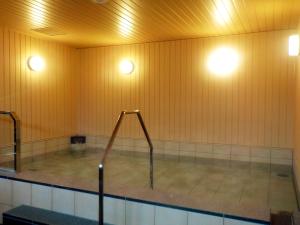 a swimming pool with two lights on the wall at Hotel Crown Hills Onahama in Iwaki