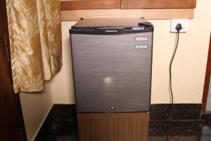 a refrigerator in the corner of a room at ShivalayaHomestay in Trichūr